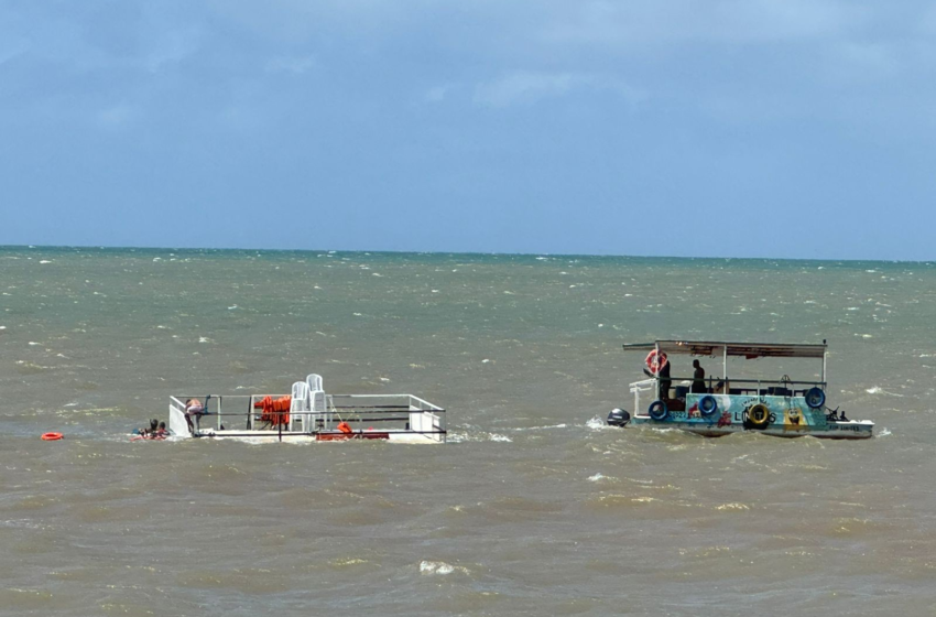 Catamarã afunda na praia do Seixas, em João Pessoa, e precisa ser retirado do mar por barco menor